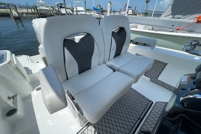 Slide: The Image of 2023 Wellcraft 242 Fisherman boat seats, featuring sleek white and black design at a marina. - 25