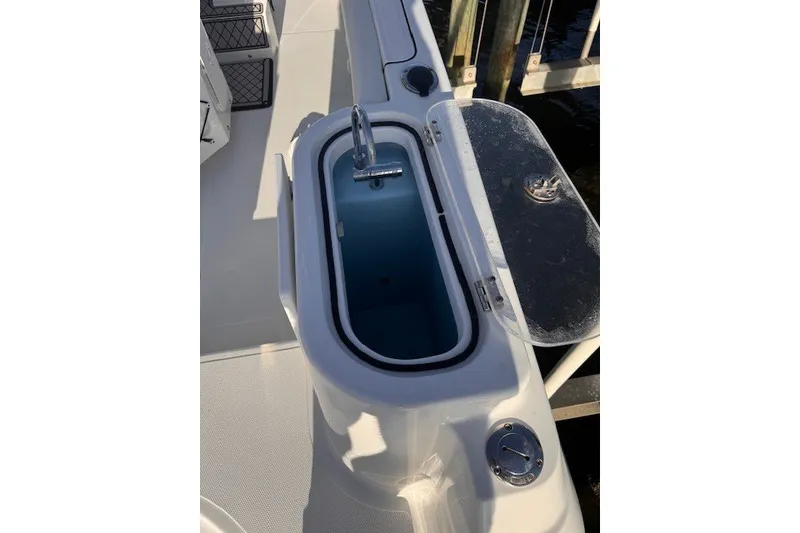 Slide: The Image of Livewell on 2023 Wellcraft 242 Fisherman boat, open lid, dockside view. - 87