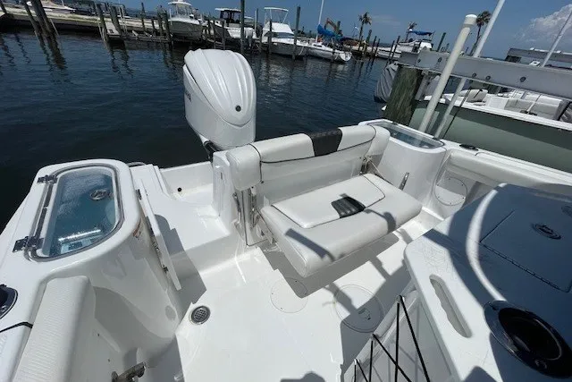 Slide: The Image of 2023 Wellcraft 242 Fisherman boat interior with seating and outboard motor at marina. - 14
