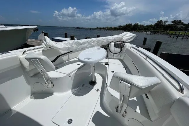 Slide: The Image of 2023 Wellcraft 242 Fisherman boat interior with seating and table, docked by the water. - 70