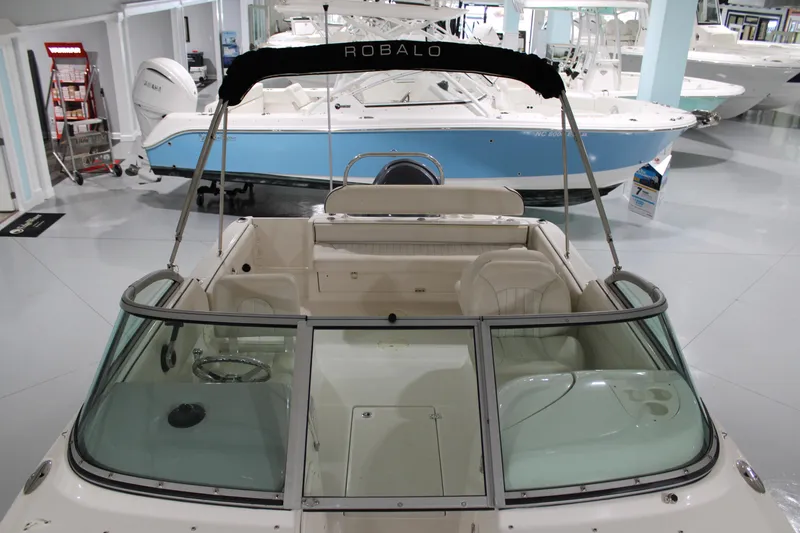 Slide: The Image of 2005 Robalo R227 Dual Console boat in showroom, featuring spacious seating and sleek design. - 37