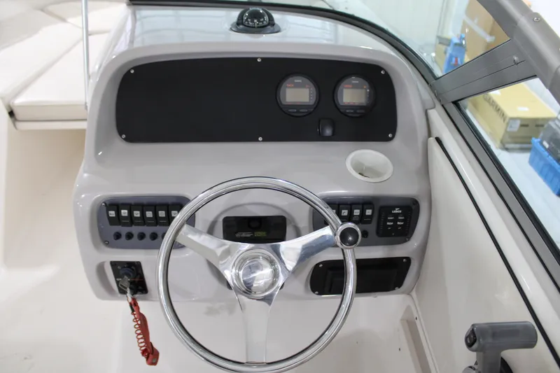 Slide: The Image of 2005 Robalo R227 Dual Console boat dashboard with steering wheel and controls. - 24