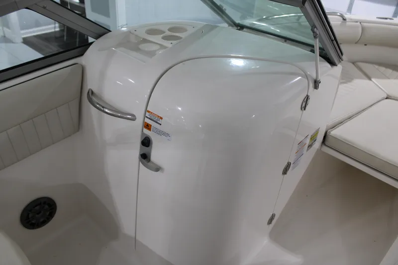 Slide: The Image of 2005 Robalo R227 Dual Console interior with white seating and storage compartment. - 17