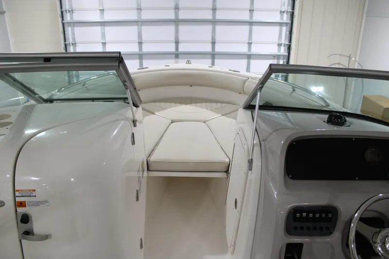 Slide: The Image of 2005 Robalo R227 Dual Console boat interior with white seating and dashboard. - 28