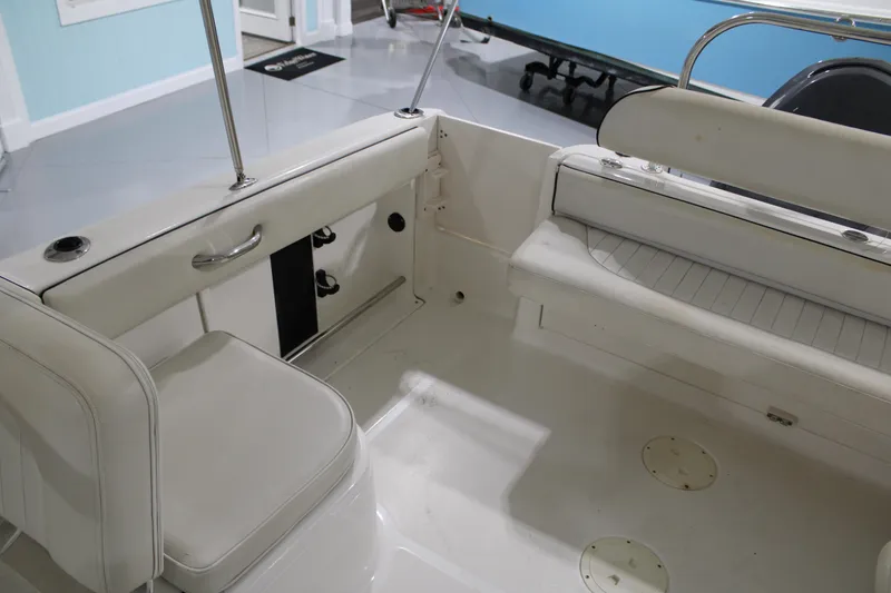 Slide: The Image of 2005 Robalo R227 Dual Console boat interior with white seating and storage compartments. - 11
