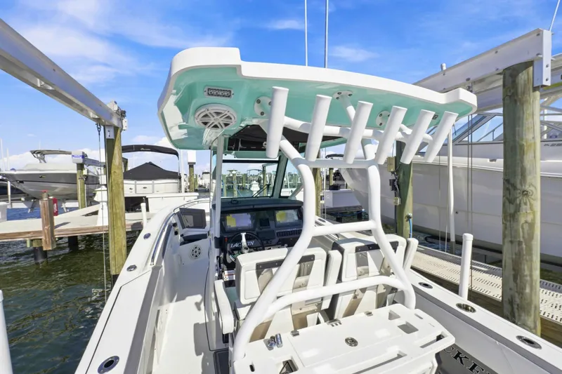 Slide: The Image of 2021 Blackfin 272 CC boat docked, showcasing helm and seating area. - 22