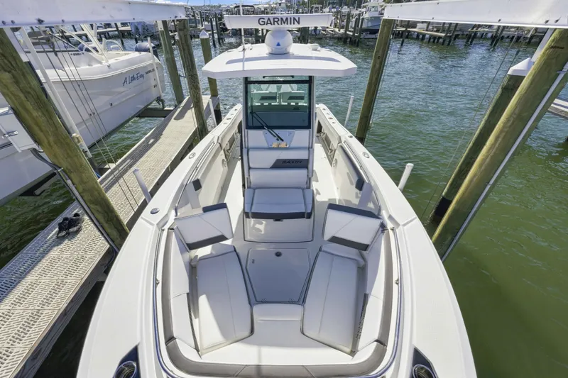Slide: The Image of 2021 Blackfin 272 CC boat docked, featuring spacious seating and Garmin navigation system. - 19