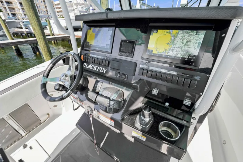 Slide: The Image of 2021 Blackfin 272 CC boat dashboard with navigation screens and steering wheel. - 17