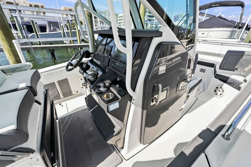 Slide: The Image of 2021 Blackfin 272 CC boat interior with modern helm and seating at marina. - 15