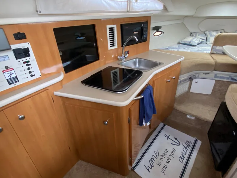 Slide: The Image of The galley of a 2002 Bayliner 2655 Ciera with sink, stove, and microwave. - 10