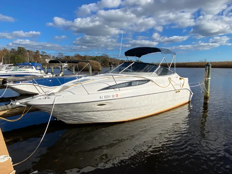 The Image of A 2002 Bayliner 2655 Ciera docked in calm waters, with a blue sky in the background. - 0
