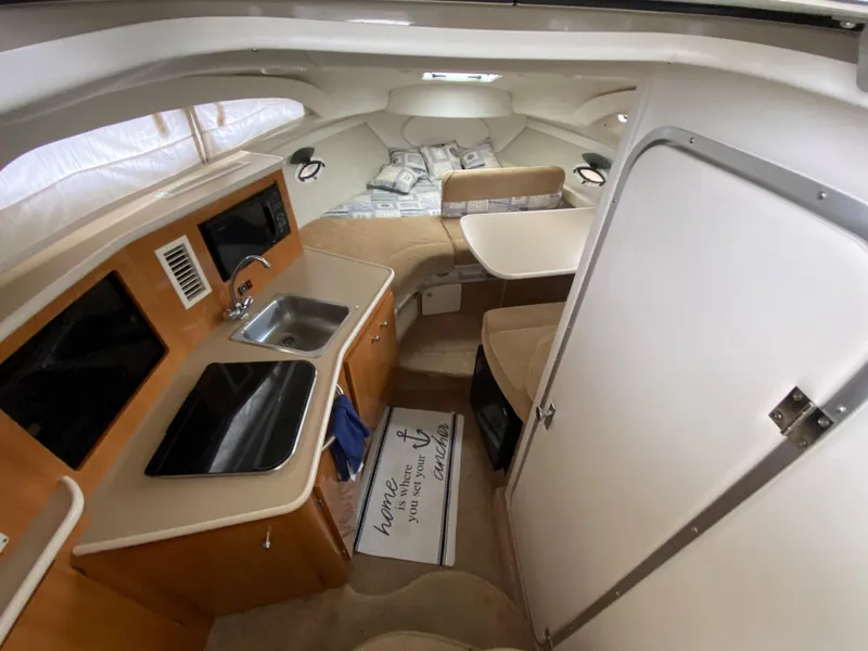 Slide: The Image of Interior of a 2002 Bayliner 2655 Ciera with kitchenette, seating area, and sleeping space. - 9