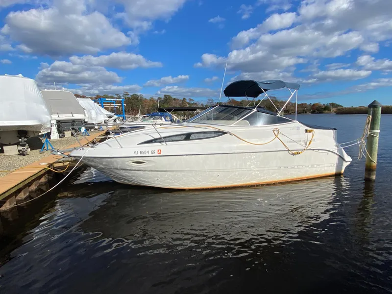 Slide: The Image of A 2002 Bayliner 2655 Ciera docked by the water. The sky is partly cloudy. - 4