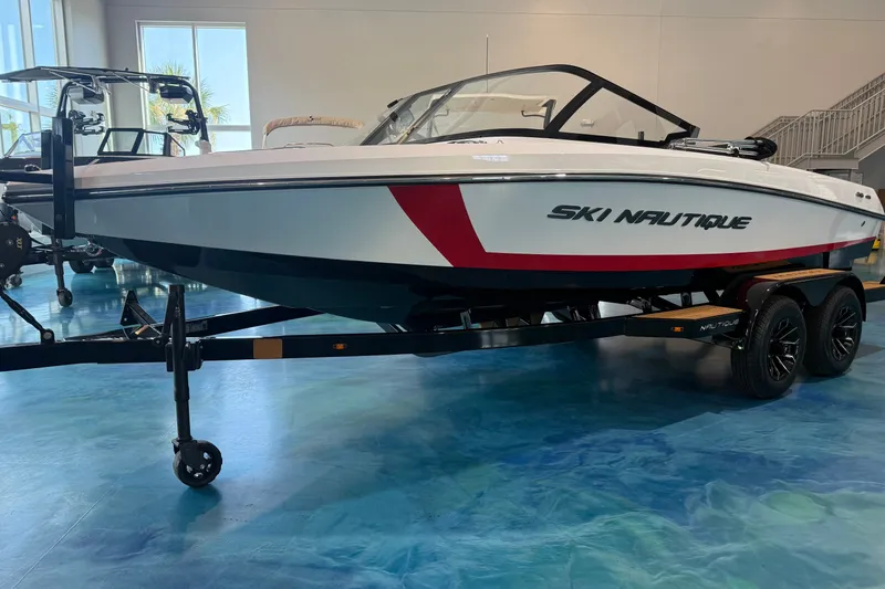 The Image of 2025 Nautique Ski Nautique 200 Open Bow boat on trailer in showroom. - 1