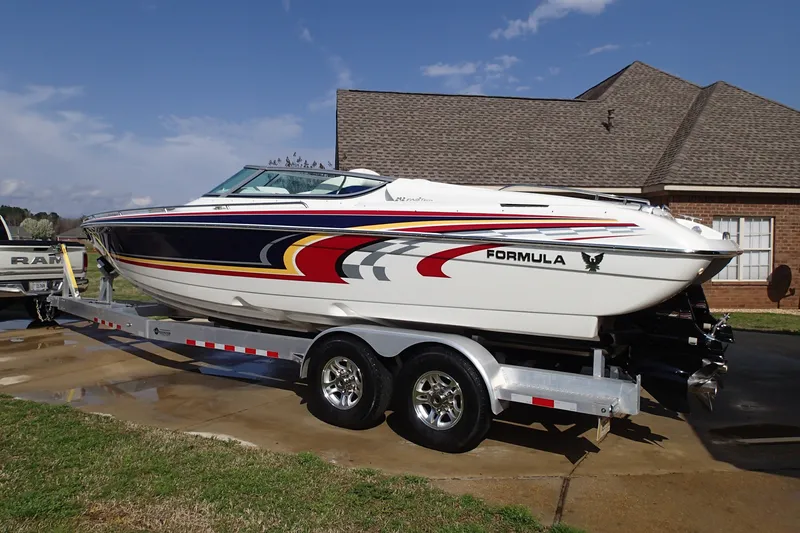 The Image of 2006 Formula 292 FASTech boat on trailer, vibrant graphics, parked in driveway. - 0