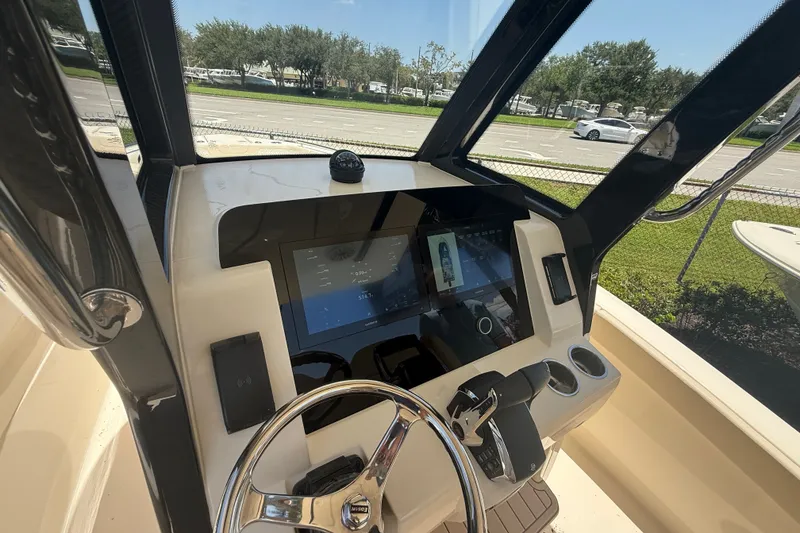 Slide: The Image of 2027 Scout 260 LXF boat dashboard with modern controls and steering wheel. - 14