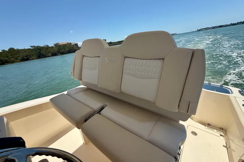 Slide: The Image of 2027 Scout 260 LXF boat with beige seating on a sunny day. - 13