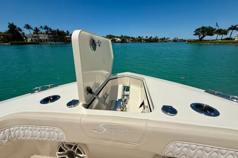 Slide: The Image of 2027 Scout 260 LXF boat with open hatch on turquoise water. - 19