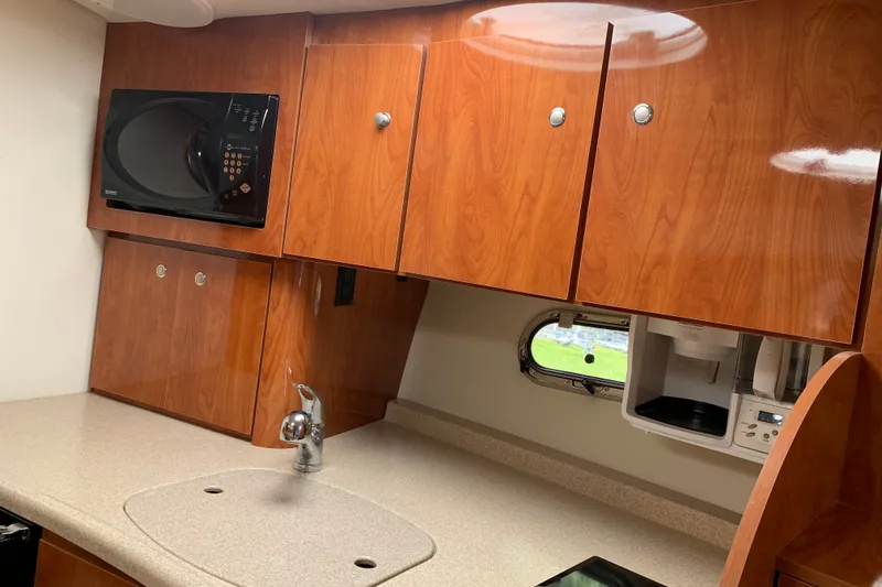 Slide: The Image of 2005 Four Winns 328 Vista boat kitchen with wood cabinets and modern appliances. - 24