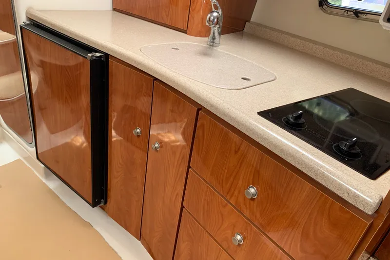 Slide: The Image of 2005 Four Winns 328 Vista boat kitchen with wood cabinets and compact appliances. - 25