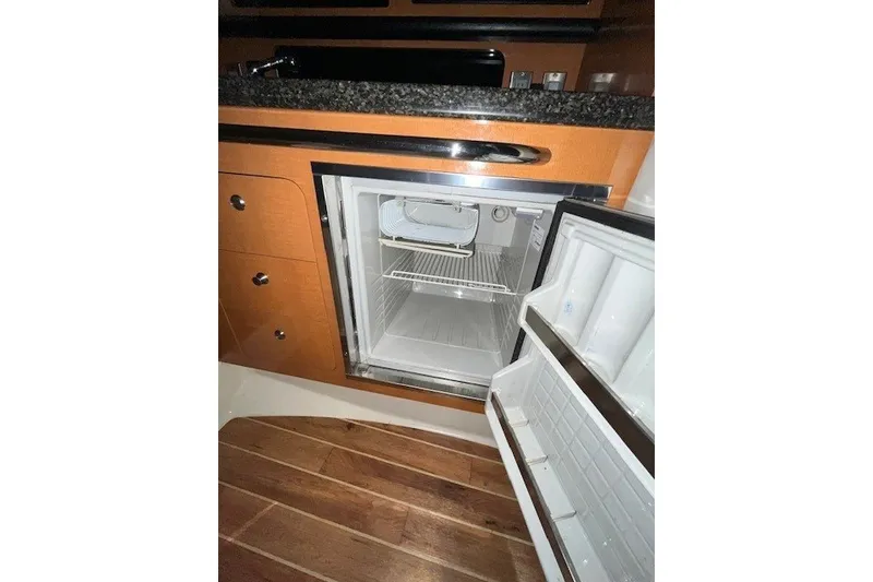 Slide: The Image of Open refrigerator in 2007 Chaparral Signature 280 boat kitchen with wooden flooring. - 15