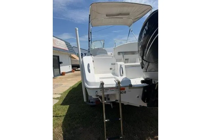 Slide: The Image of 2008 Sea Pro 228 Dual Console boat with ladder and canopy, parked outdoors. - 7