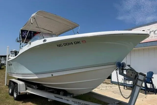 Slide: The Image of 2008 Sea Pro 228 Dual Console boat on trailer, with canopy, parked outdoors. - 2