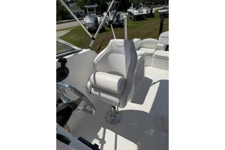 Slide: The Image of 2008 Sea Pro 228 Dual Console boat interior with white captain's chair and steering wheel. - 18