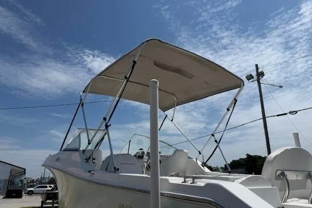 Slide: The Image of 2008 Sea Pro 228 Dual Console boat with canopy under a clear blue sky. - 6