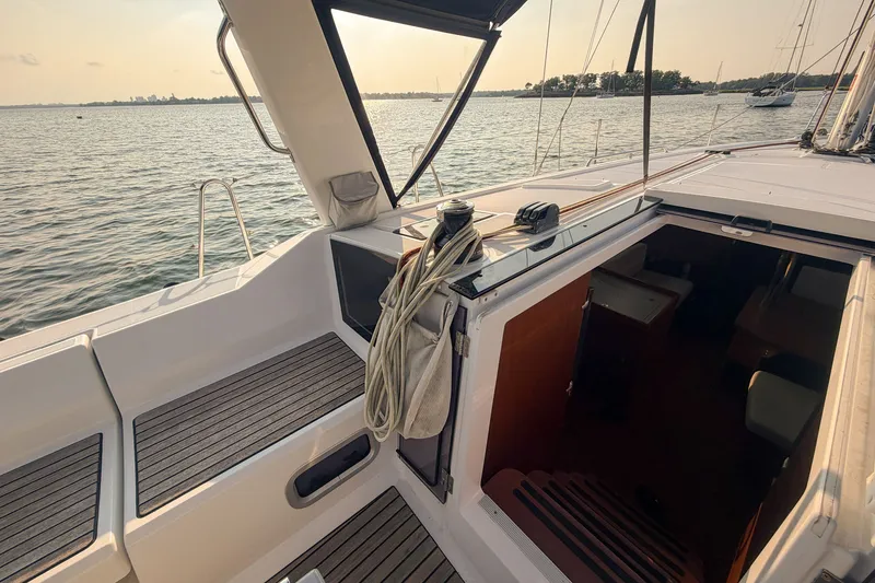 Slide: The Image of 2021 Beneteau Oceanis 41.1 sailboat cockpit with open cabin, overlooking serene waters. - 23