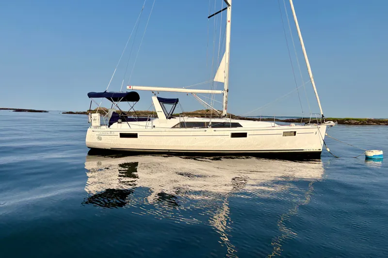 Slide: The Image of 2021 Beneteau Oceanis 41.1 sailboat anchored on calm water under clear blue sky. - 5