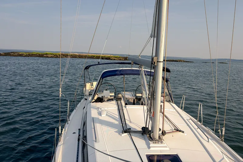 Slide: The Image of 2021 Beneteau Oceanis 41.1 sailboat on calm waters with scenic island backdrop. - 9