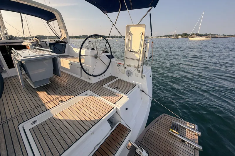 Slide: The Image of 2021 Beneteau Oceanis 41.1 yacht deck with steering wheel, docked on calm waters. - 21