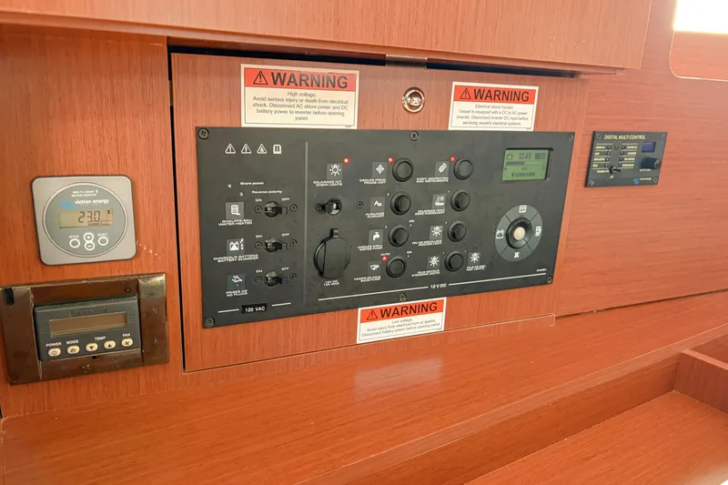 Slide: The Image of Control panel of a 2021 Beneteau Oceanis 41.1 sailboat, featuring warning labels and digital displays. - 51