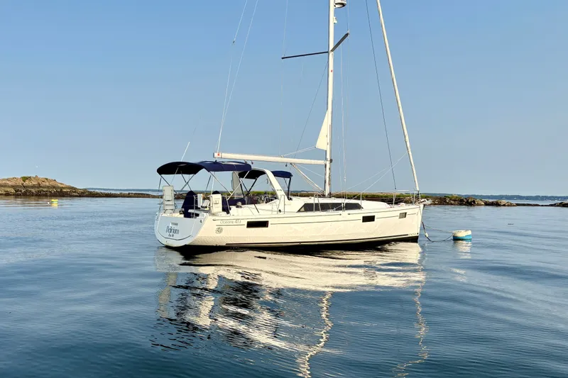 Slide: The Image of 2021 Beneteau Oceanis 41.1 sailboat anchored on calm water, clear sky background. - 4