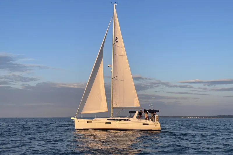 The Image of 2021 Beneteau Oceanis 41.1 sailing on open water at sunset. - 1