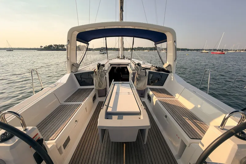 Slide: The Image of 2021 Beneteau Oceanis 41.1 sailboat cockpit with teak decking, anchored in serene waters. - 12