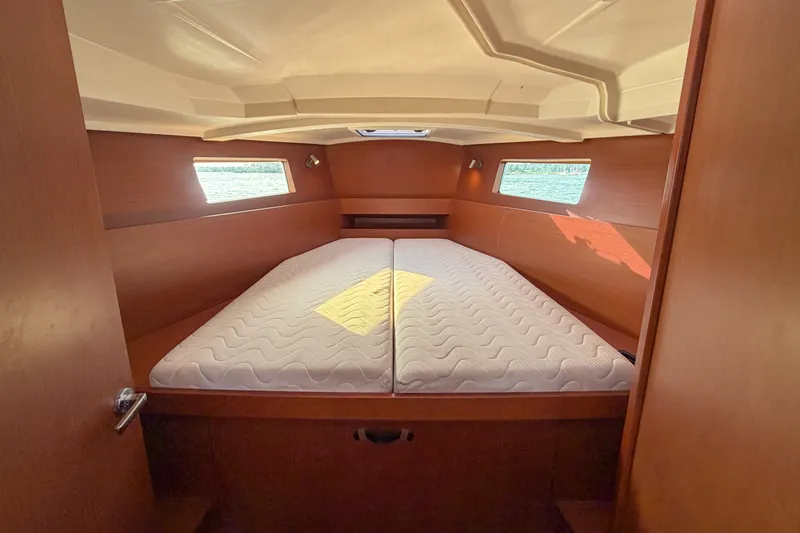 Slide: The Image of Interior cabin of 2021 Beneteau Oceanis 41.1 yacht with twin mattresses and wooden finish. - 42