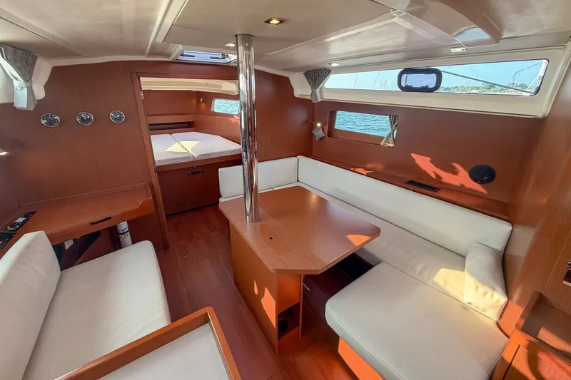 Slide: The Image of Interior of 2021 Beneteau Oceanis 41.1 yacht with wood finish and white seating. - 35