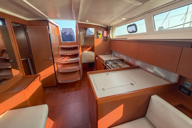 Slide: The Image of Interior of 2021 Beneteau Oceanis 41.1 yacht, featuring modern kitchen and wooden cabinetry. - 32