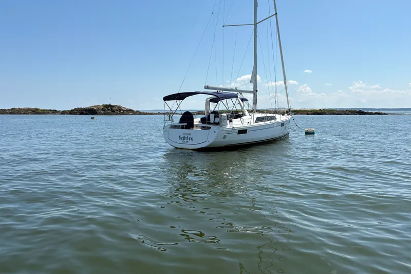 Slide: The Image of 2021 Beneteau Oceanis 41.1 sailboat anchored in calm waters under a clear blue sky. - 3