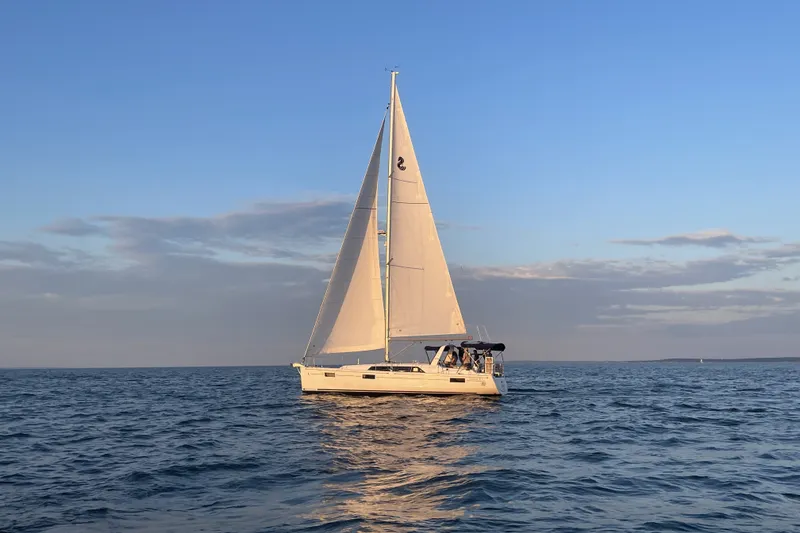 Slide: The Image of 2021 Beneteau Oceanis 41.1 sailboat cruising on open sea at sunset. - 2