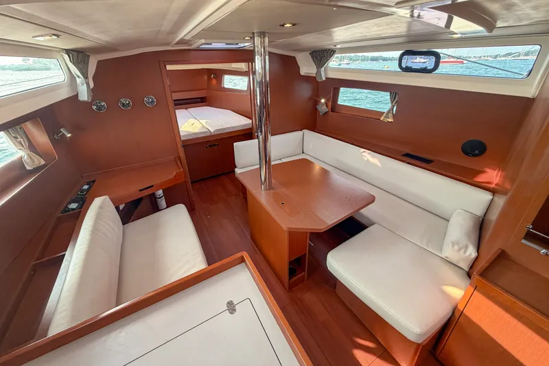 Slide: The Image of Interior of 2021 Beneteau Oceanis 41.1 yacht, featuring elegant wood finish and cozy seating. - 31