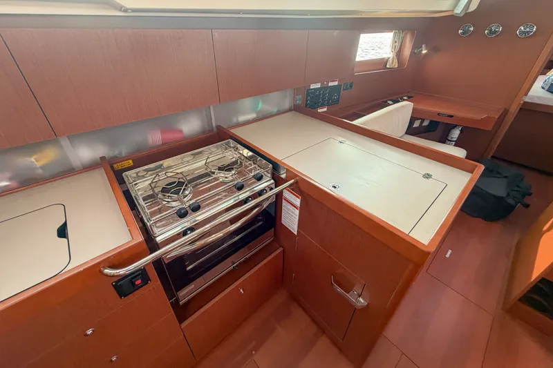 Slide: The Image of Interior of 2021 Beneteau Oceanis 41.1 yacht, featuring a modern kitchen with stove and cabinetry. - 38