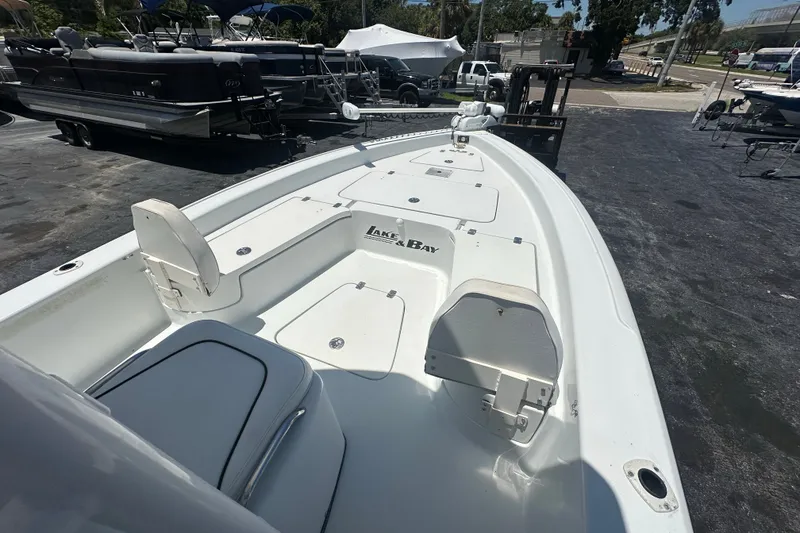 Slide: The Image of 2007 Lake & Bay Backwater 24 boat, white deck, parked in marina with other boats. - 7