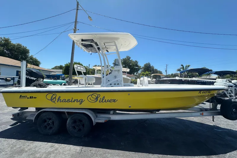 Slide: The Image of 2007 Lake & Bay Backwater 24 boat on trailer, yellow hull, "Chasing Silver" text. - 5