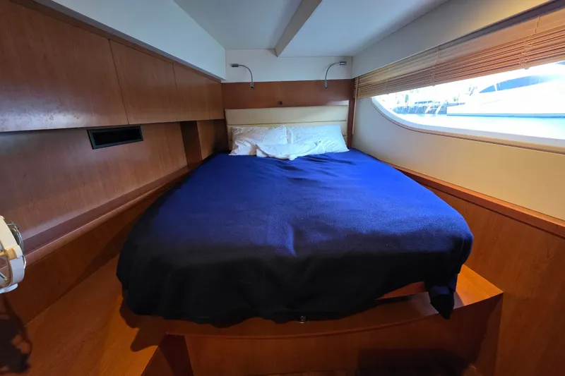 Slide: The Image of Cozy bedroom interior of 2016 Aquila 48 yacht with wooden paneling and large window. - 25