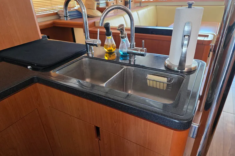 Slide: The Image of Modern kitchen sink area on a 2016 Aquila 48 yacht with wooden cabinetry. - 19