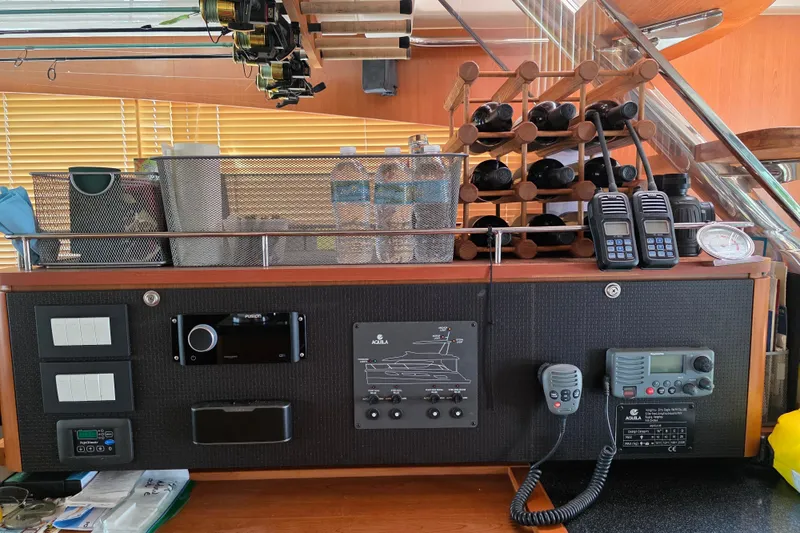 Slide: The Image of Control panel and storage area on a 2016 Aquila 48 yacht, featuring electronics and wine rack. - 17