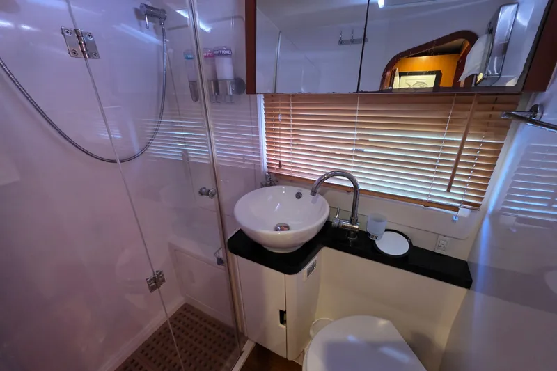 Slide: The Image of Luxurious bathroom in 2016 Aquila 48 yacht with modern fixtures and wooden blinds. - 28